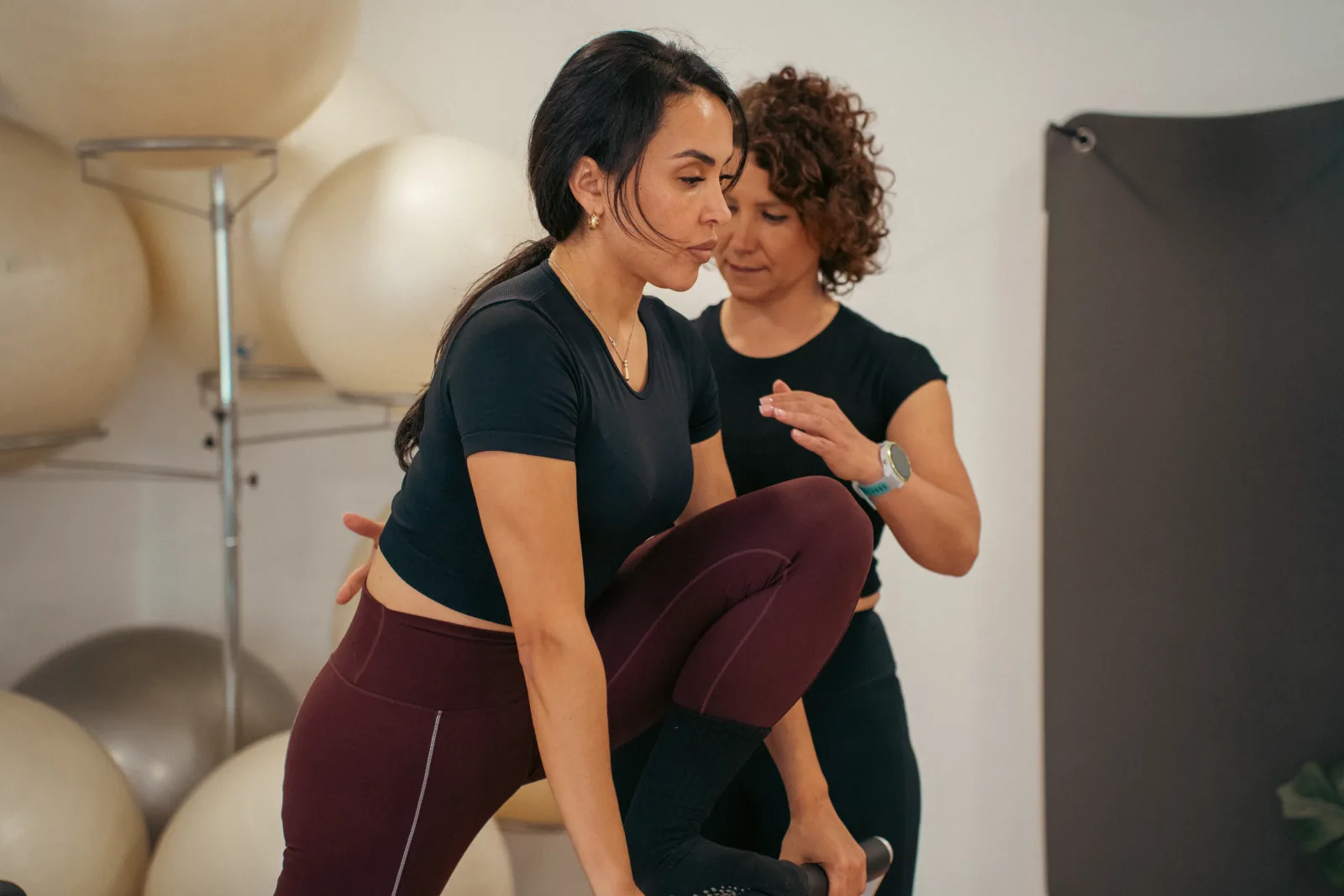 Corrección técnica durante una clase de Pilates